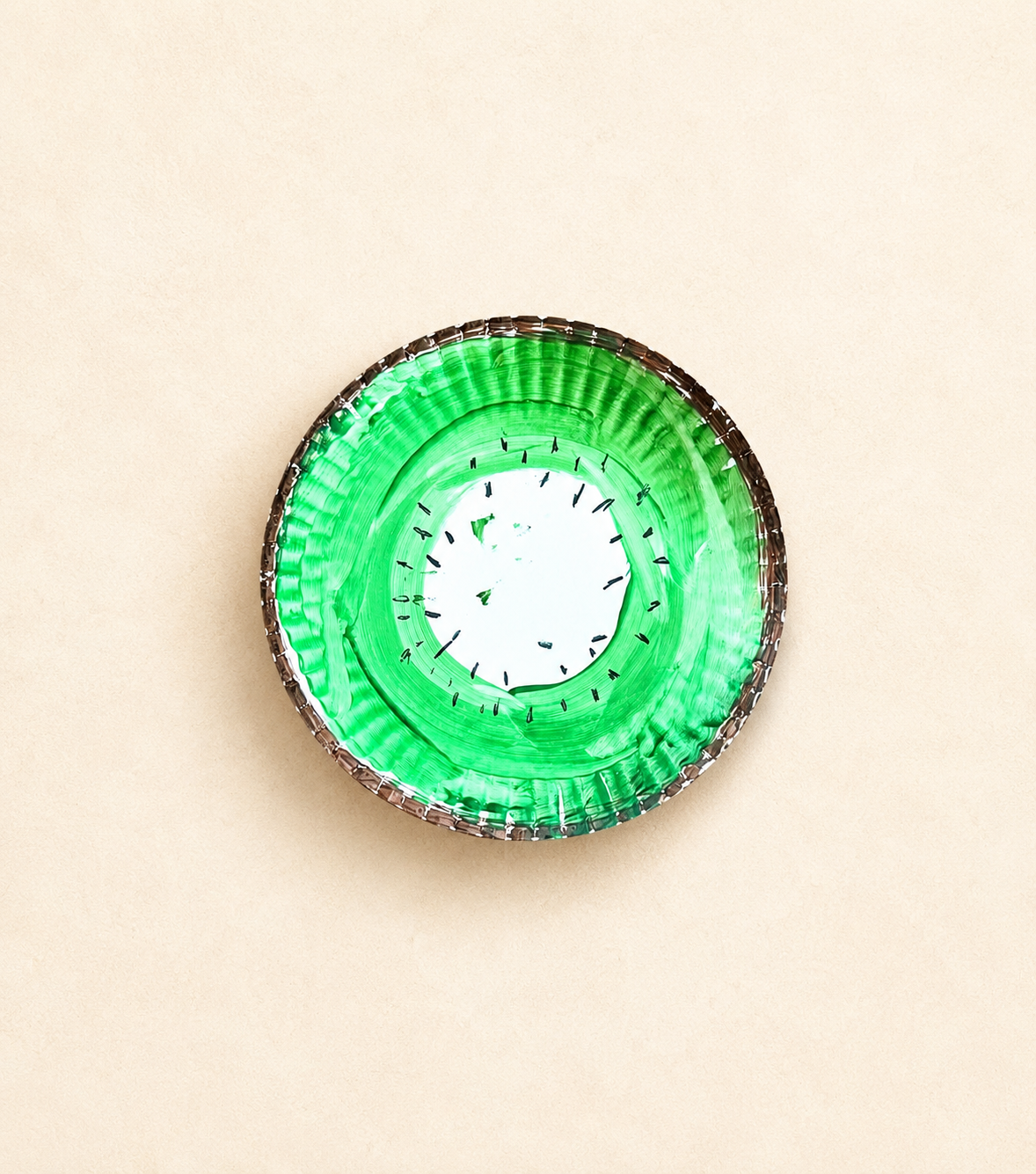Preschool paper plate kiwi craft painted green with a brown edge and black seeds