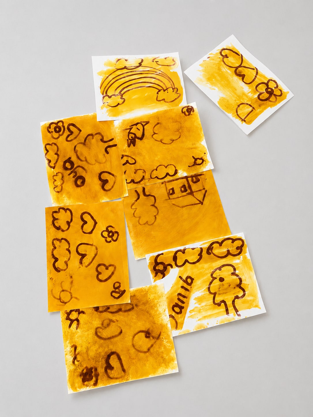 Preschool turmeric and baking soda magic art pages with yellow turmeric paint and brown hidden drawings