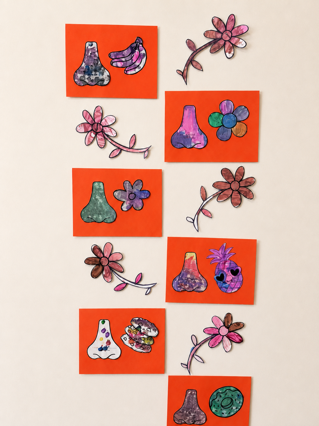 Preschool five senses smell artwork with painted nose shapes, flowers, fruit, and food pictures