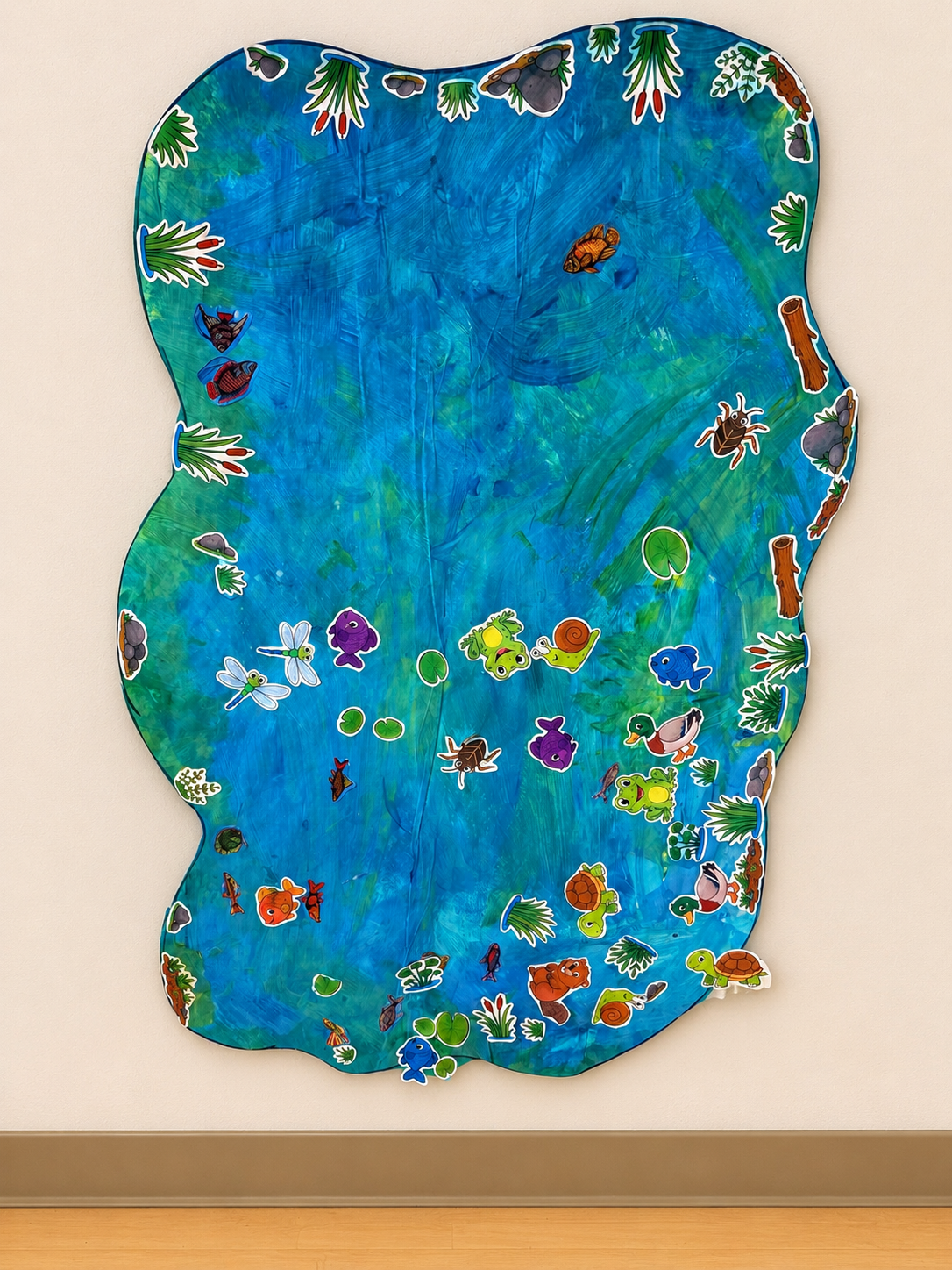 Large collaborative preschool pond mural with painted blue water and pond animal cutouts